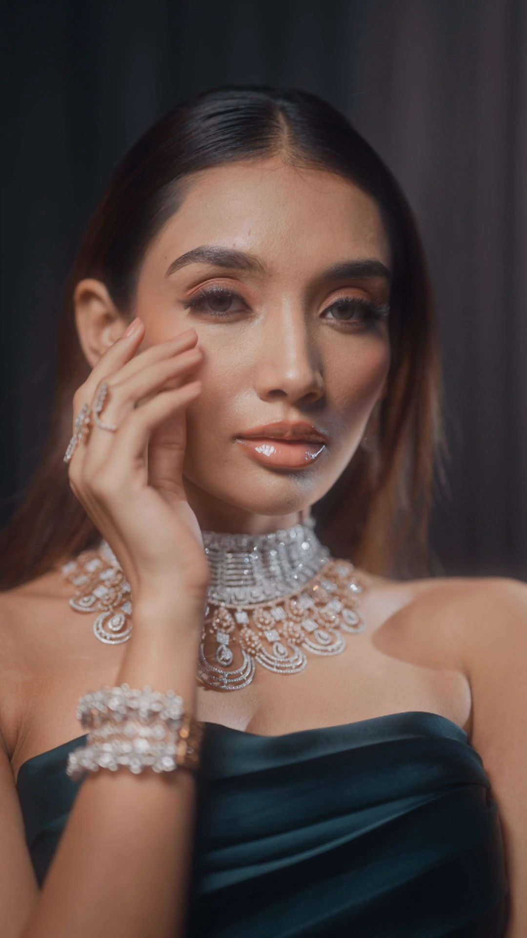 Sancheti Gems model facing the camera against dark drapery